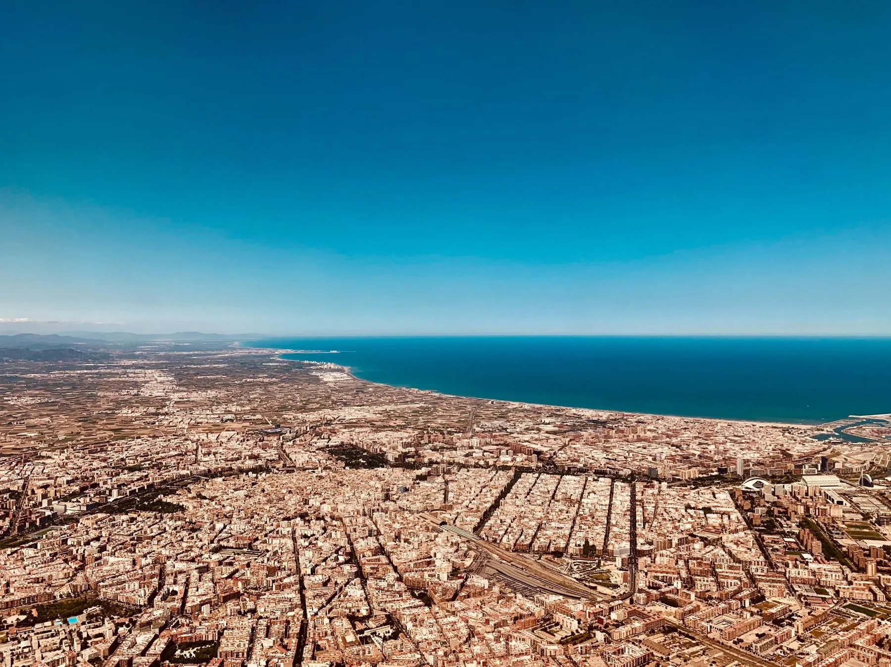 Vista aérea de València con la huerta, la ciudad y la costa mediterránea