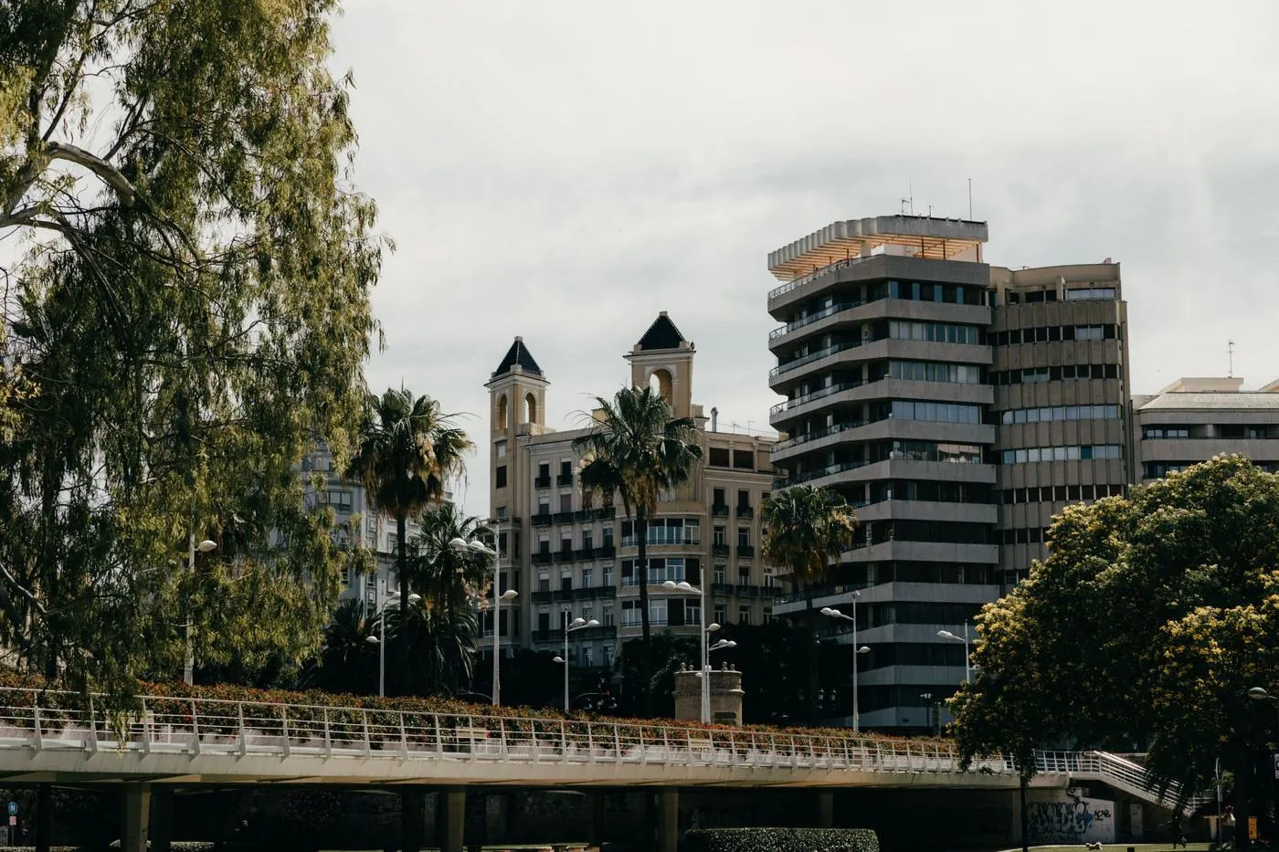 Puente sobre el jardín del Turia con edificios residenciales y palmeras