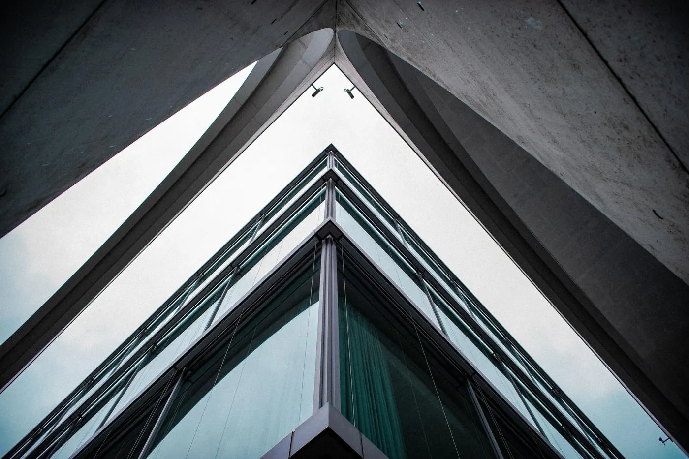 Esquina de un edificio de vidrio y hormigón vista desde abajo